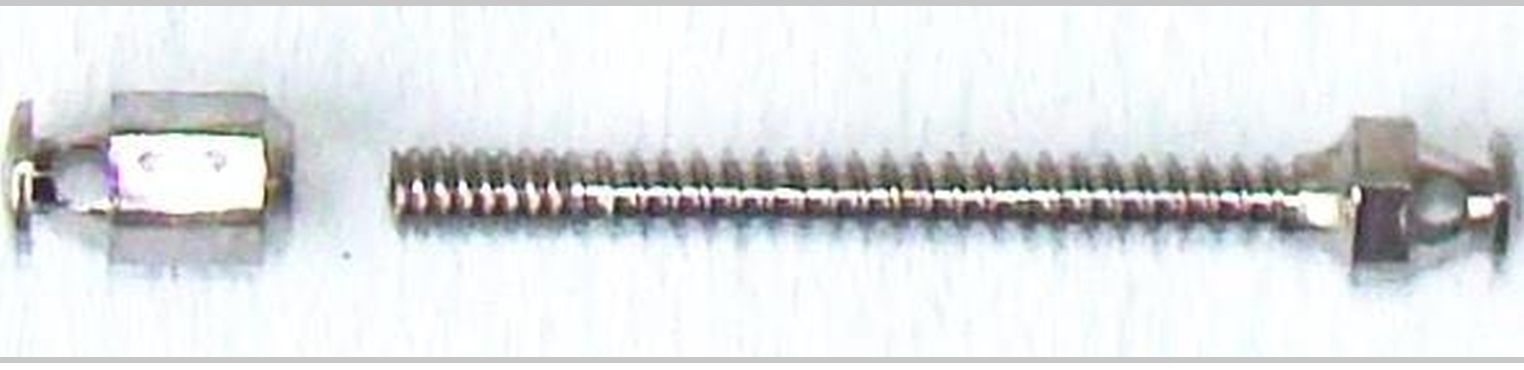 The manufactured device in titanium alloy: the second head, the threaded shaft, and the first head.